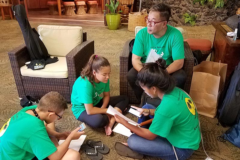 NextGen Pono, Tai, and Mālie reviewing their performance with Kumu Alan Akaka at the 2018 Maui Steel Guitar Festival