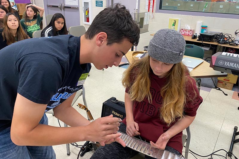 Ethan Goore shows a Chiefess Kamakahelei Middle School (Kaua&lsquo;i) student how finger picks are used